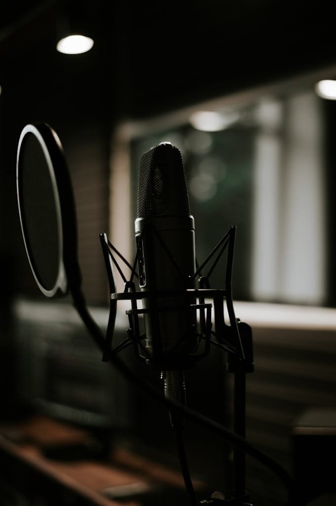 Close-up of a microphone in a moody recording studio setting, ideal for music production themes.